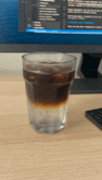 Une boisson dans un verre sur un bureau de travail.