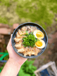 A hand holding a plate of food.